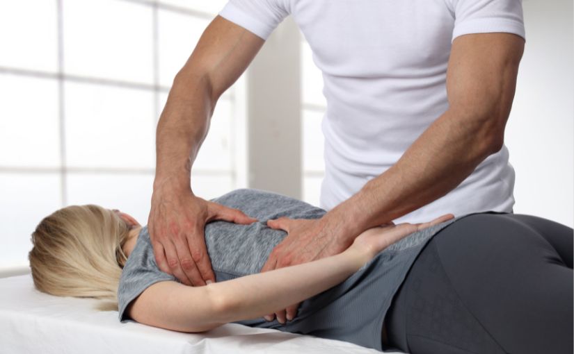 chiropractor doing soft tissue massage on female patient.