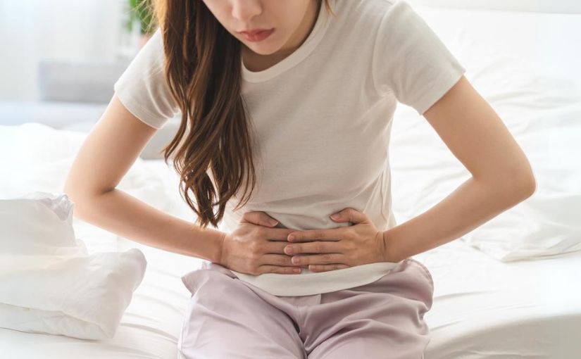 Person touching stomach because of pain and discomfort