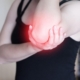 Person holding elbow because of pain and discomfort