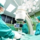 A team of surgeons in green scrubs collaborates in an operating room, engaged in a surgical procedure.