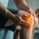 A person holding his knee with a pained expression, suggesting pain.