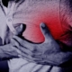 A person clutching his chest, showing signs of distress from a heart attack