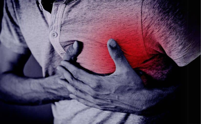 A person clutching his chest, showing signs of distress from a heart attack
