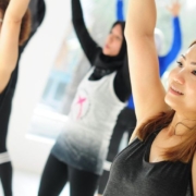 A group of women practicing aerobics in a gym, focusing on their poses and maintaining balance