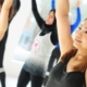 A group of women practicing aerobics in a gym, focusing on their poses and maintaining balance