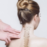 A person with back pain receives an examination from a chiropractor in a clinical setting.
