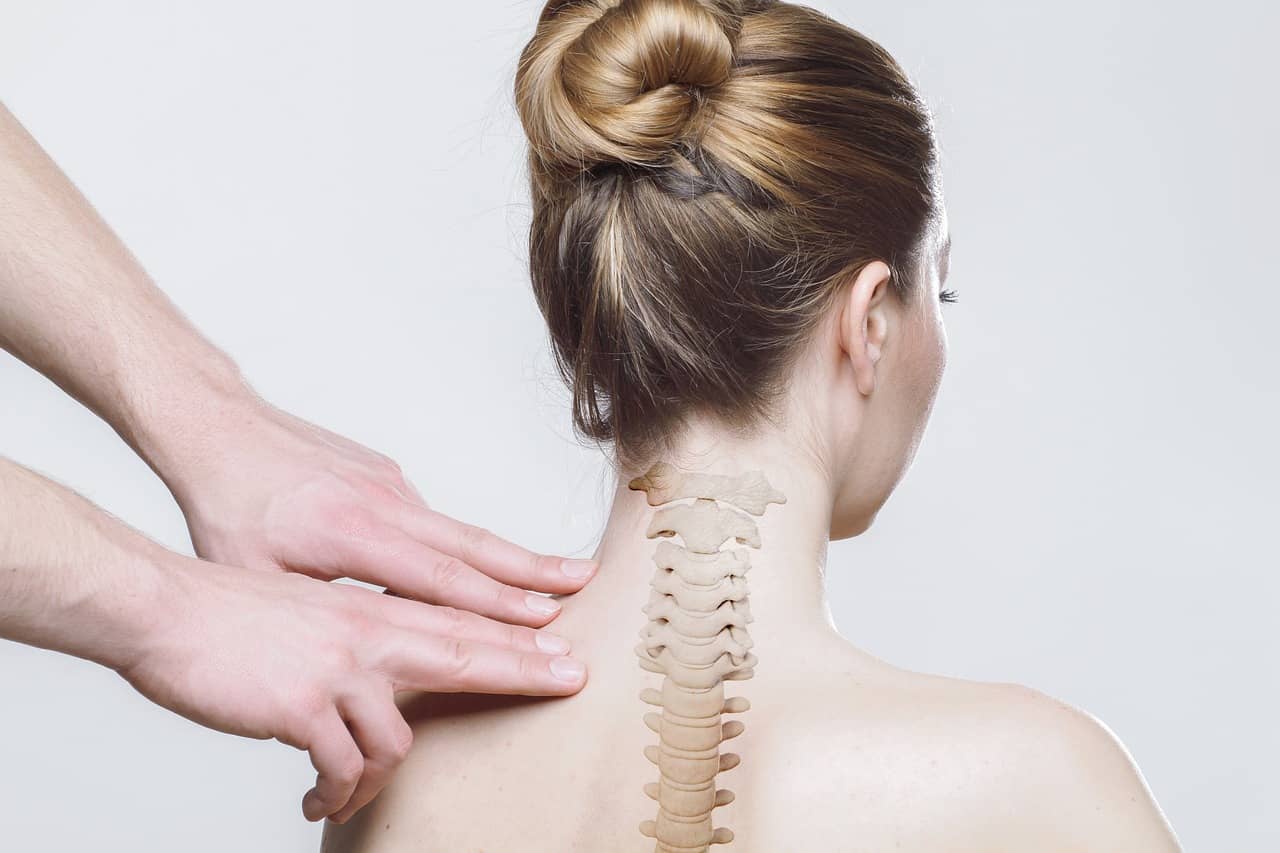 A person with back pain receives an examination from a chiropractor in a clinical setting.