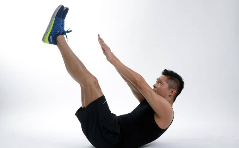 A person performing a side plank exercise, balancing on one arm with his body in a straight line.