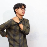 person holding shoulder and back due to pain and discomfort