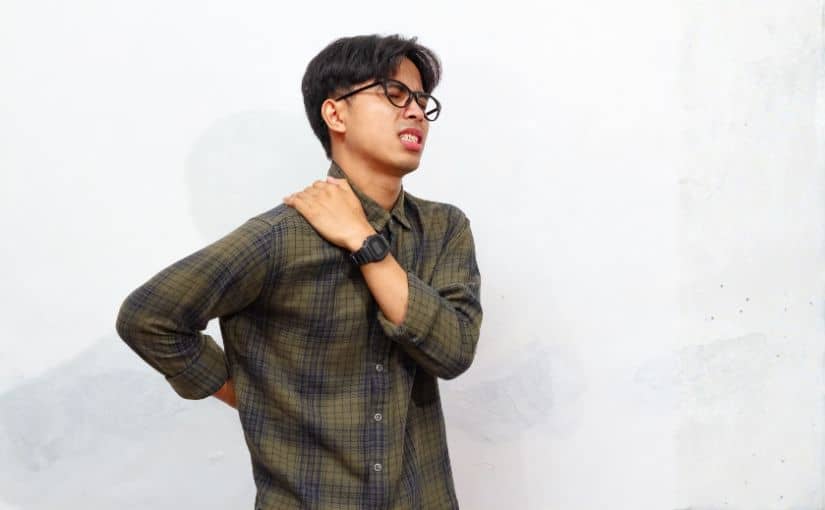 person holding shoulder and back due to pain and discomfort 