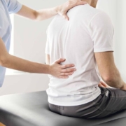 chiro doctor assessing back of patient for pain