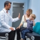 chiro doctor high fives child with mother in a clinic