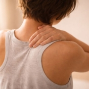 Person holding upper back because of pain and discomfort