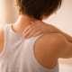 Person holding upper back because of pain and discomfort