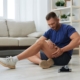 person sitting on the floor holding legs because of pain